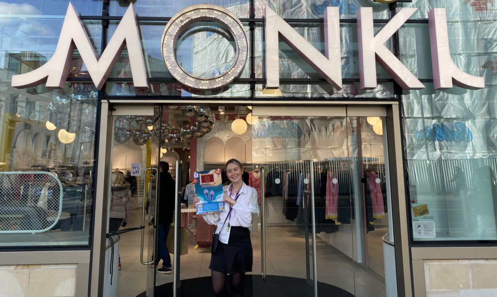 Meagan Hall, store manager of Monki, holding the Lunar New Year Trail poster