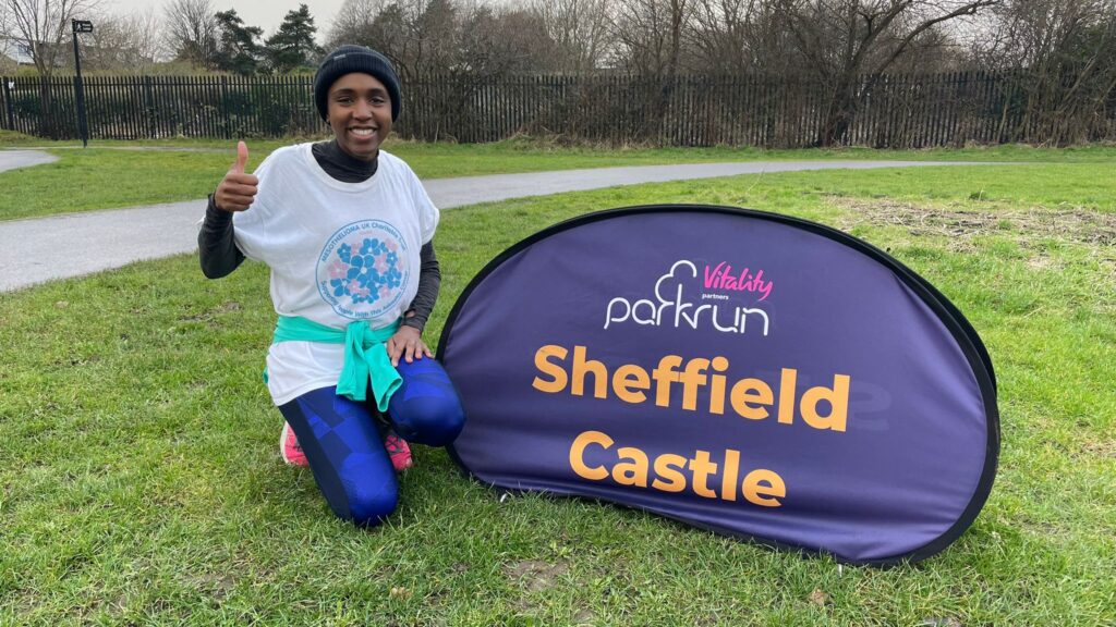 Woman posing in front of ParkRun sign