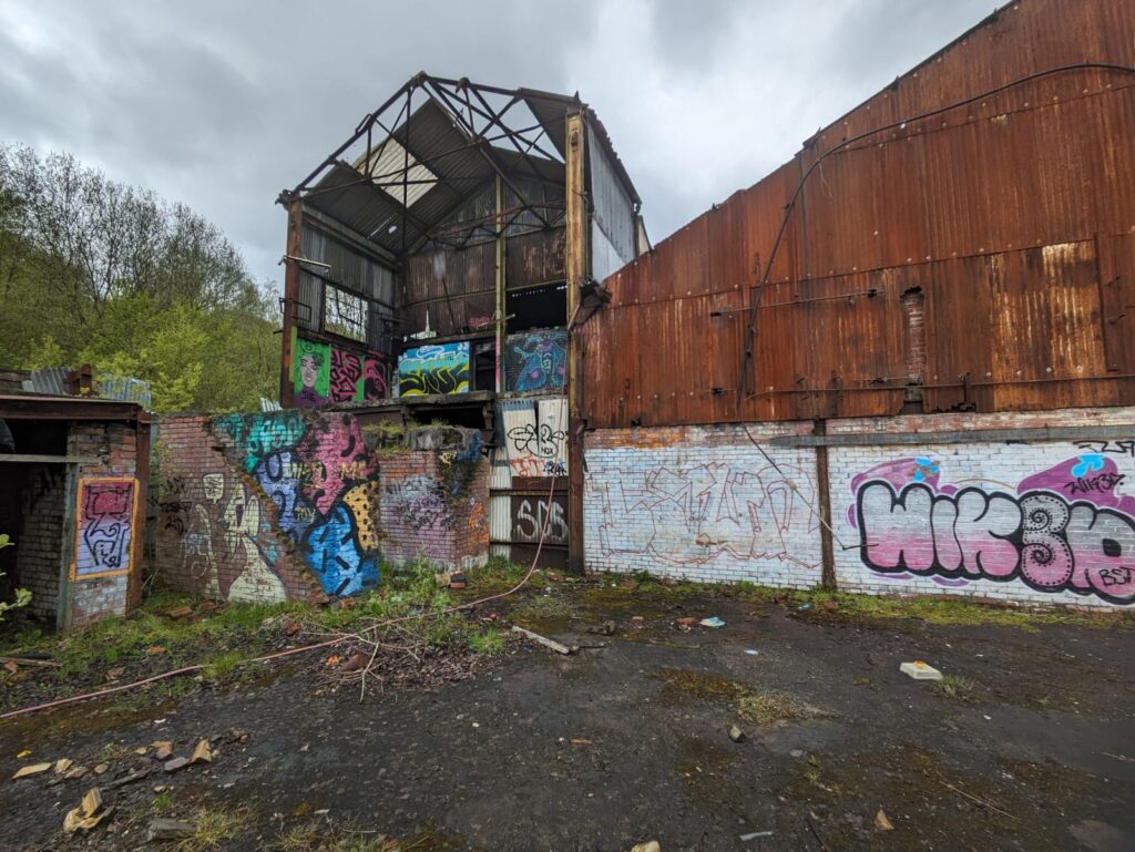 Disused rundown factory building from the outside with graffiti on
