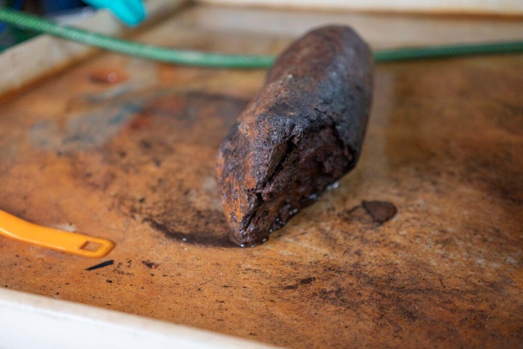 A close up photo of a wooden stake found at the site.