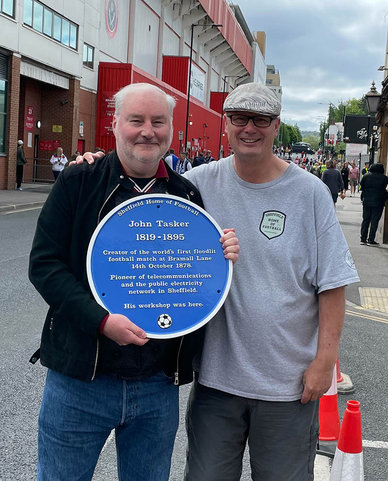 The blue plaque dedicated to John Tasker held at Bramall Lane by Charity Trustee Chris Wood