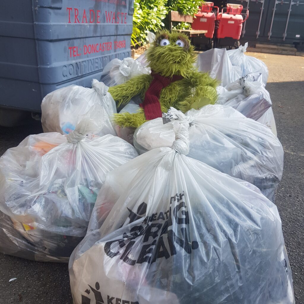 Green teddy sat above a pile of rubbish collected by volunteers.