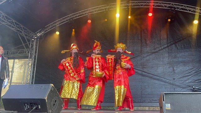 3 men in traditional Chinese dress on stage