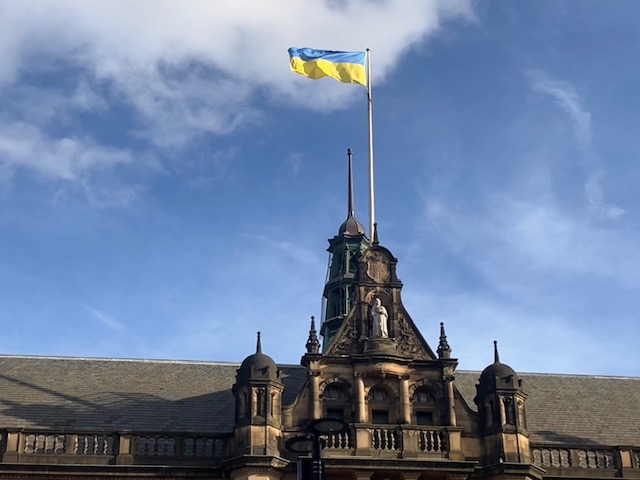 A close-up picture of The Ukrainian flag flying over Sheffield Council's Town hall with a background of blue skies