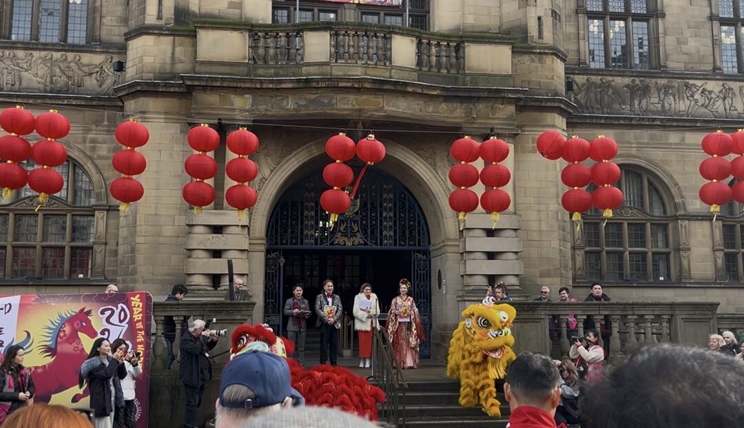 two hosts standing outside Sheffield town hall making the opening speeches
