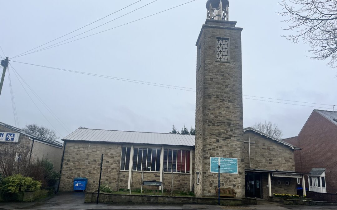 St Columba's Church Crosspool Sheffield, beige stone bricks with a tower on the right. Sky is overcast and grey.