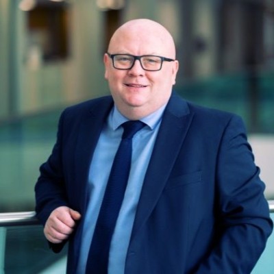 Steve Kay imaged in a blue suit smiling