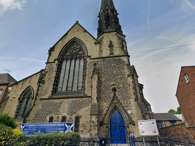 Exterior of gothic-style stone church with a tall spire and bright blue doors