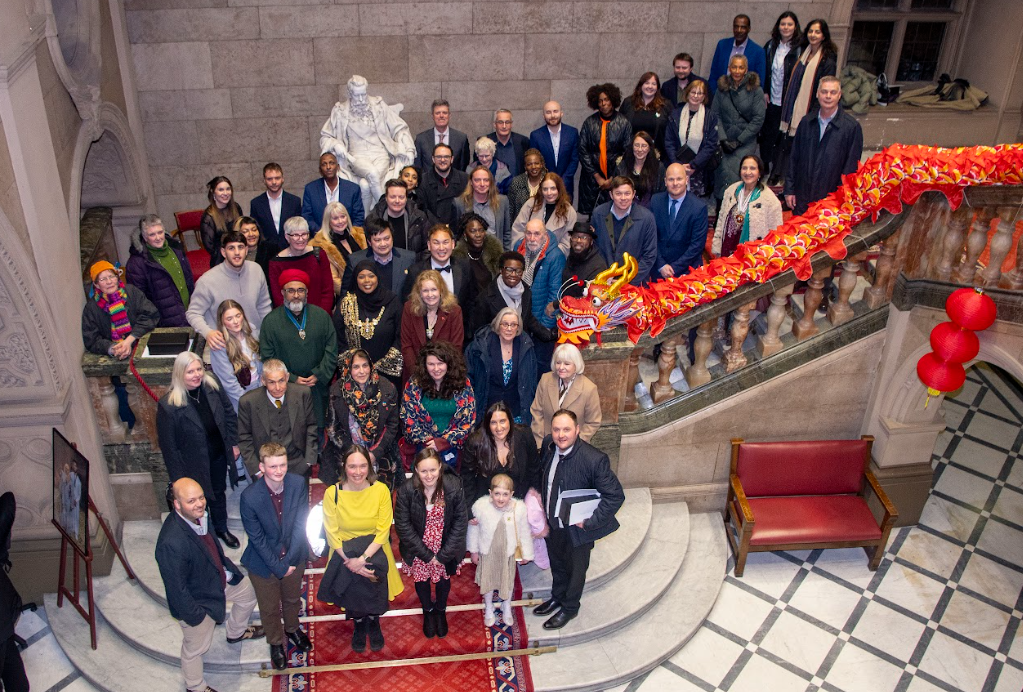 All the attendees of the Sheffield Lord Mayor awards, stood on a large staircase, looking up at the camera. 