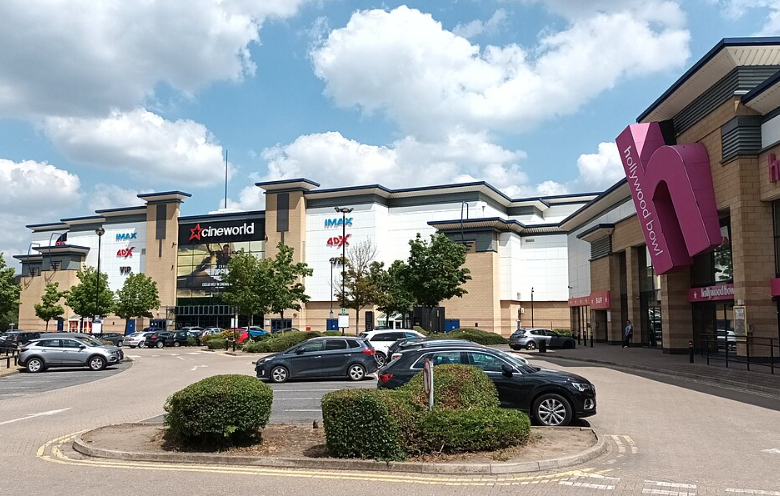 A leisure complex, with cars parked in the foreground and a Cineworld and hollywood bowl in the background