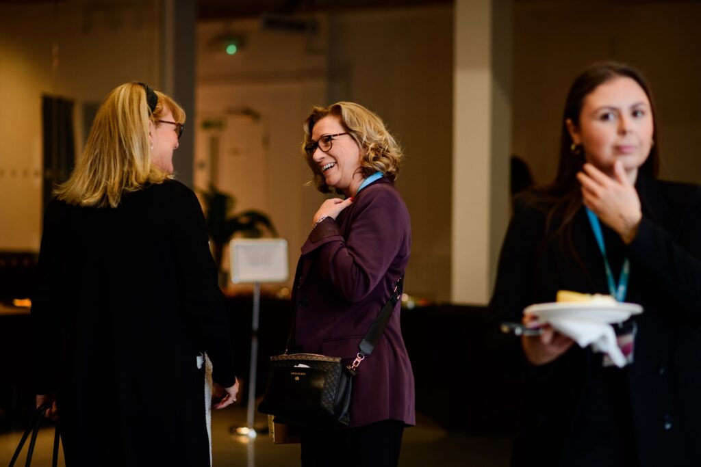 an image three women standing at the conference