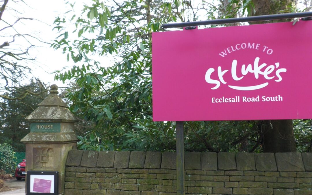 A sign saying "St lukes Hospice" in white lettering on a pink background