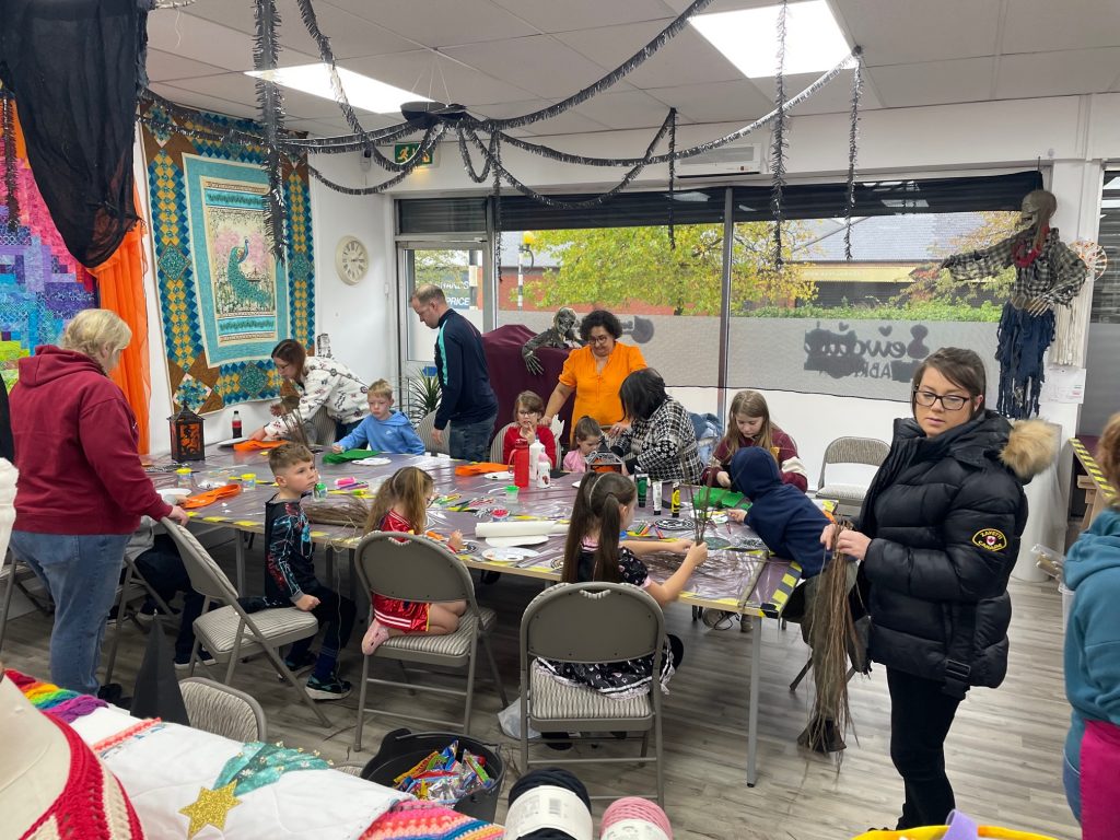 children sat around a table in halloween costumes 