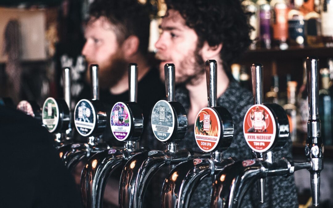 A picture of a line of signs of beer at a pub