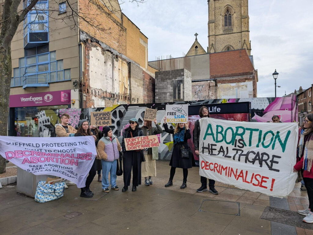 Members of Worker's Liberty attending a counter protest holding signs that support the decriminalisation of abortion.