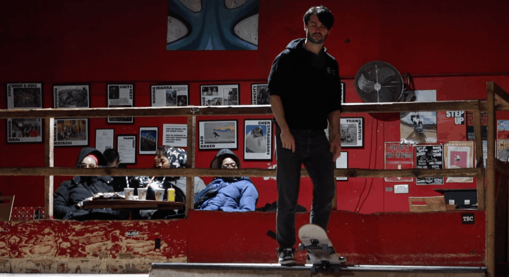 A skateboarder preparing to go down a quater pipe ramp.