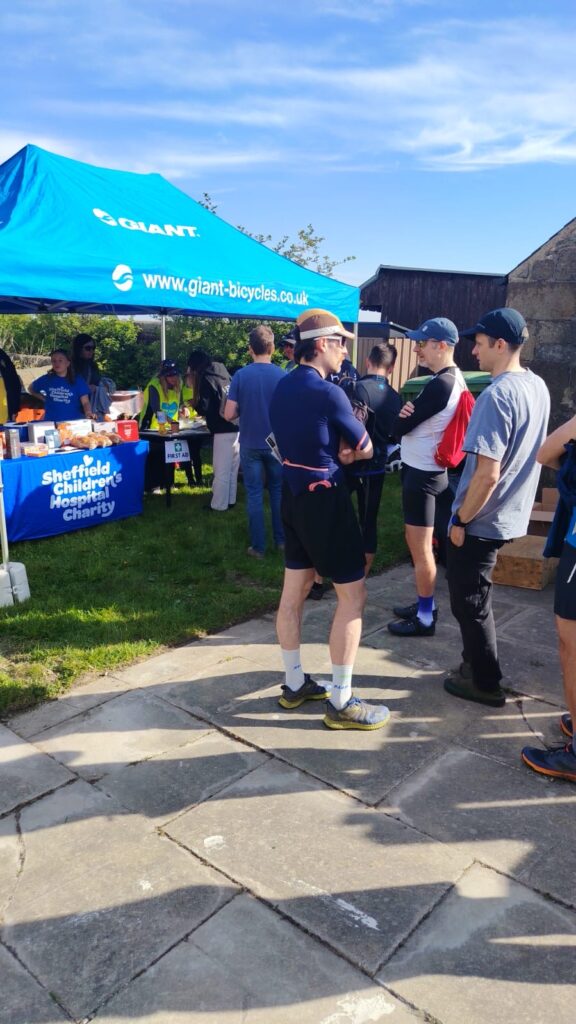 Athletes in front of a 'Giant Sheffield' gazebo.