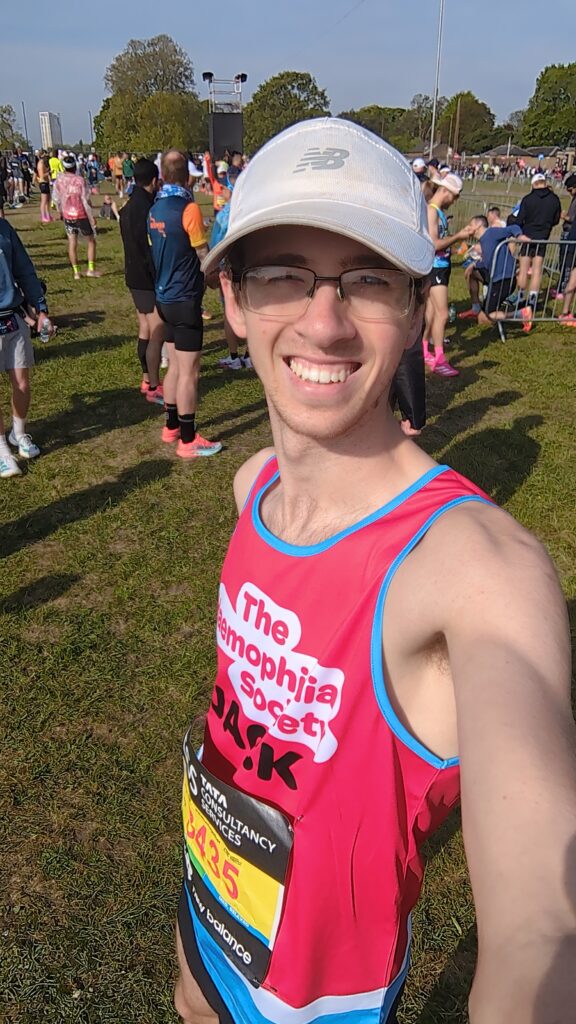 A man with a cap and running vest, before a race
