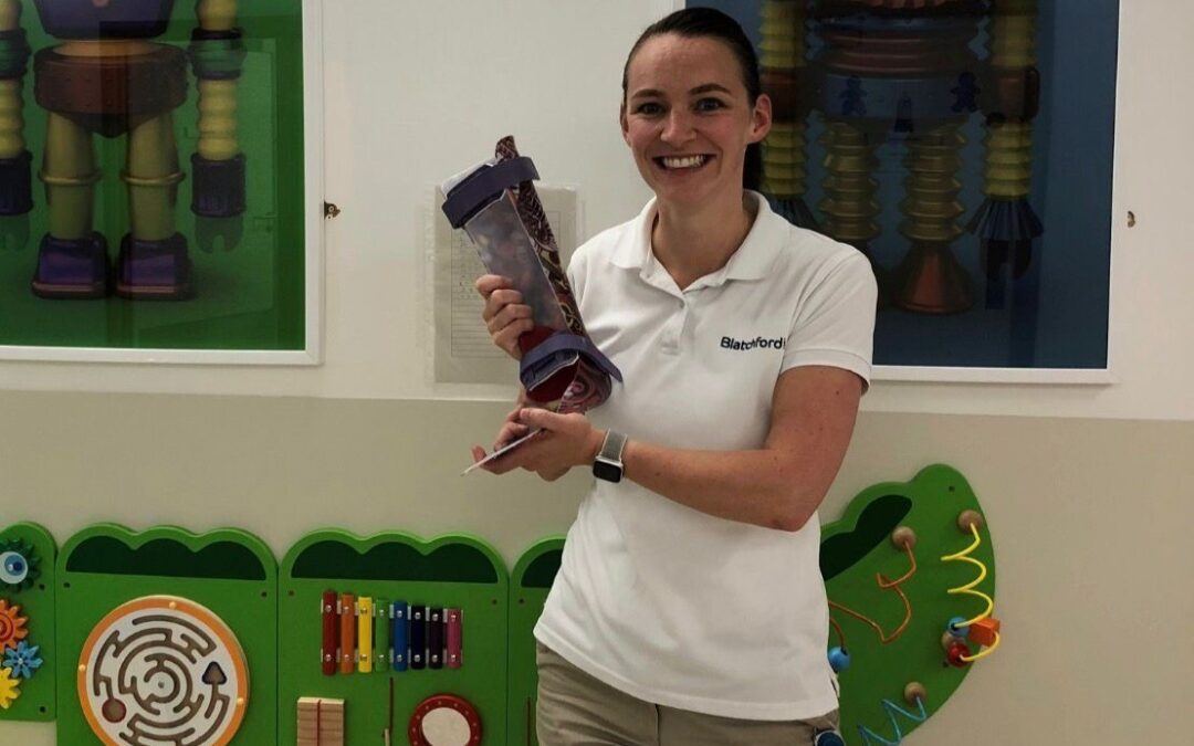 A woman inside a children's area of a hospital holding a children's toy