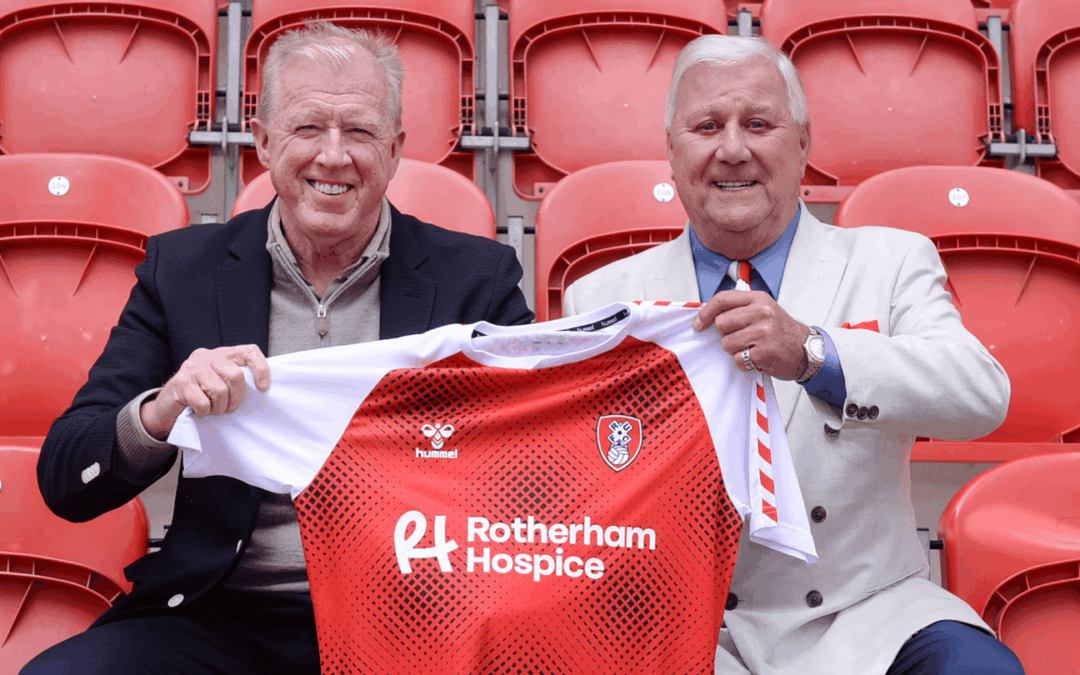 Tony Stewart and Steve McClaren hold the Rotherham United shirt together whilst sitting in the stand.