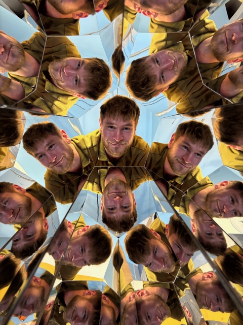 Man in several mirrors reflecting his face
