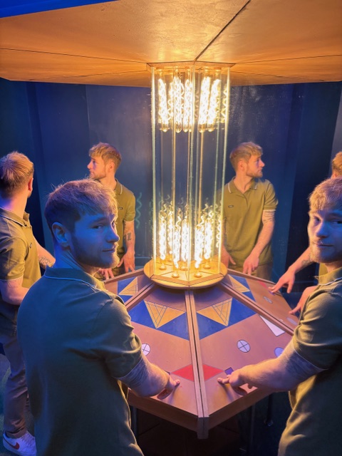 Man in a room with lots of mirrors that looks like a tardis