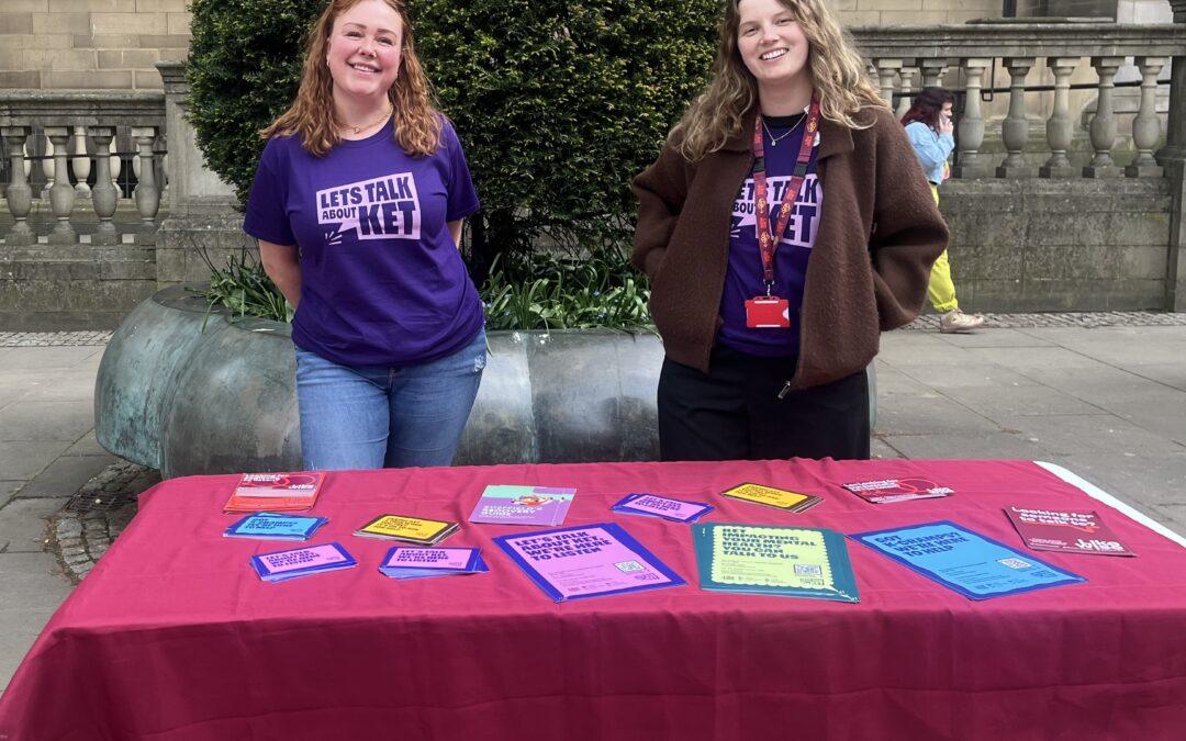 An image of two volunteers behind the stall table.