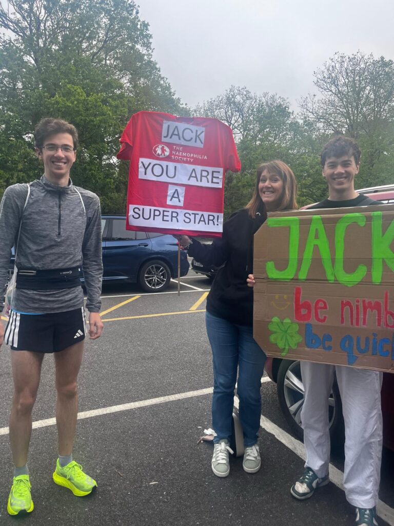 A man and his family holding signs to cheer him on
