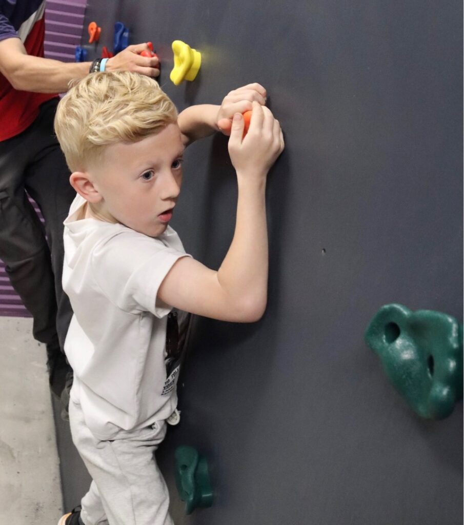 boy on a rock climbing wall