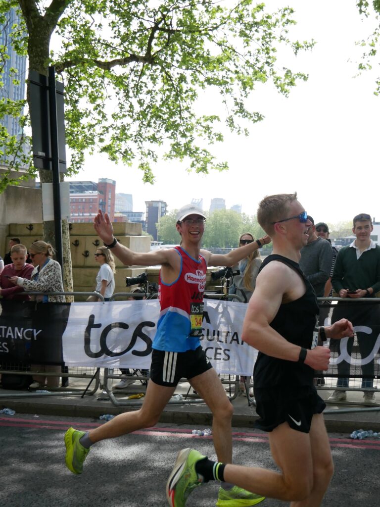 A man with his arms out, celebrating his run
